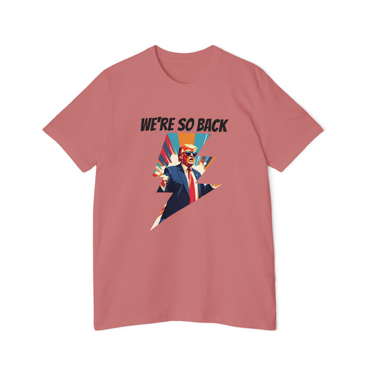 Pink T-shirt featuring a dynamic graphic design with a stylized image of Donald Trump in a suit and red tie, standing with his arms outstretched. Above the image, the text reads 'WE'RE SO BACK' in bold black letters