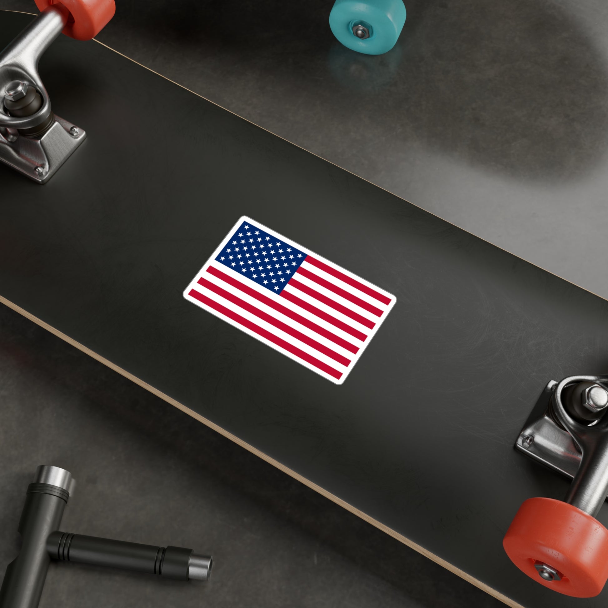 A USA flag sticker being displayed on a skate board. 